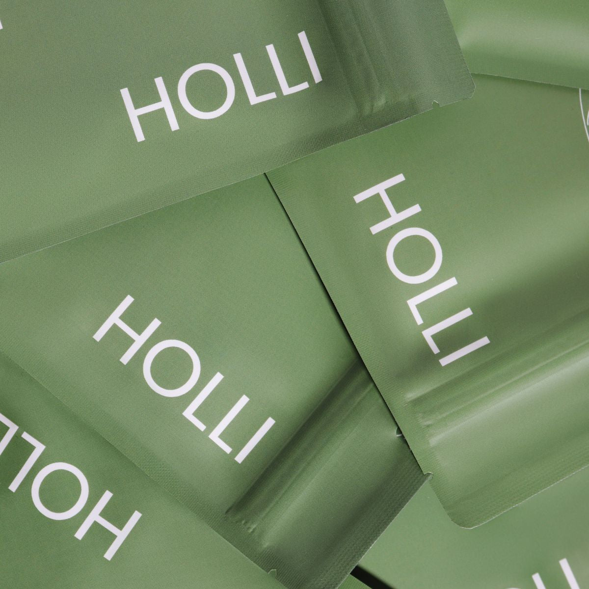 Green Kinesiology Face Tape packages with 'HOLLI' branding on a close-up view