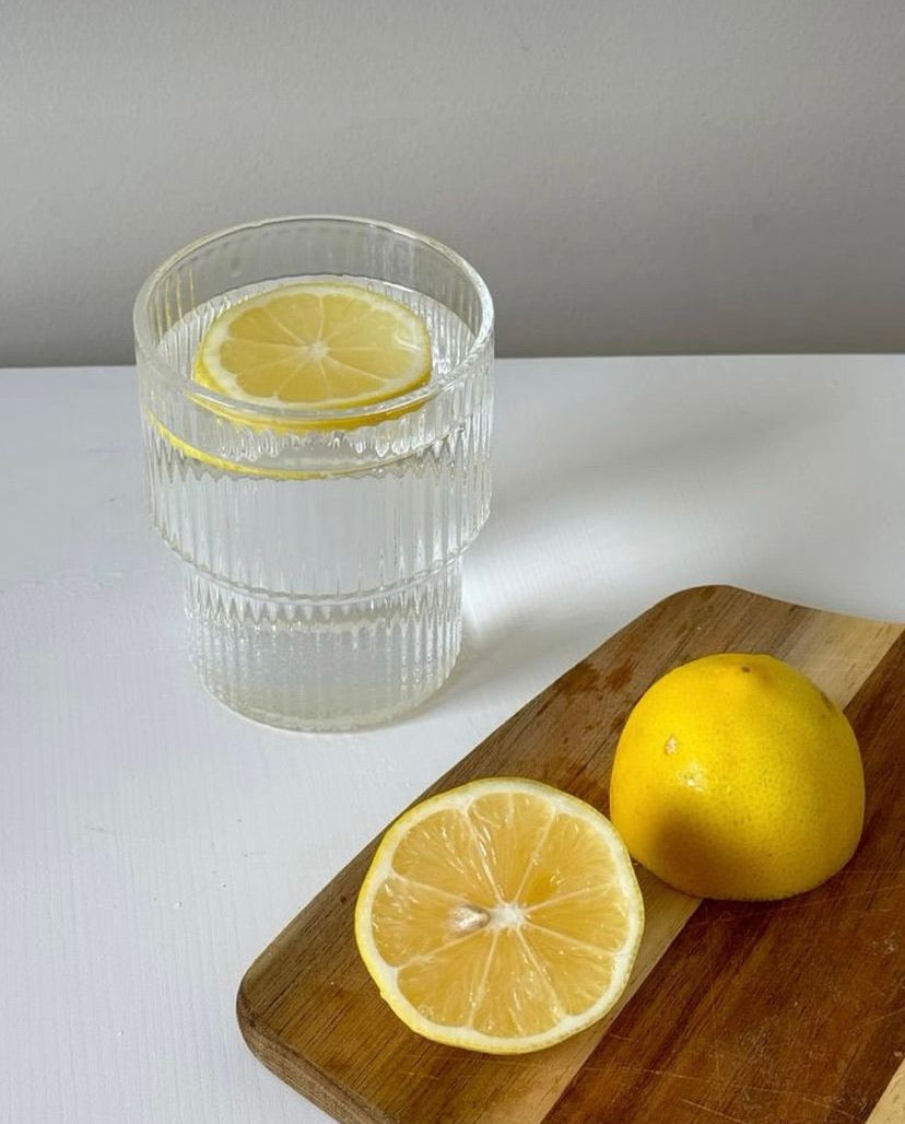 Glass of lemon water symbolizing clean hydration and holistic wellness in skincare