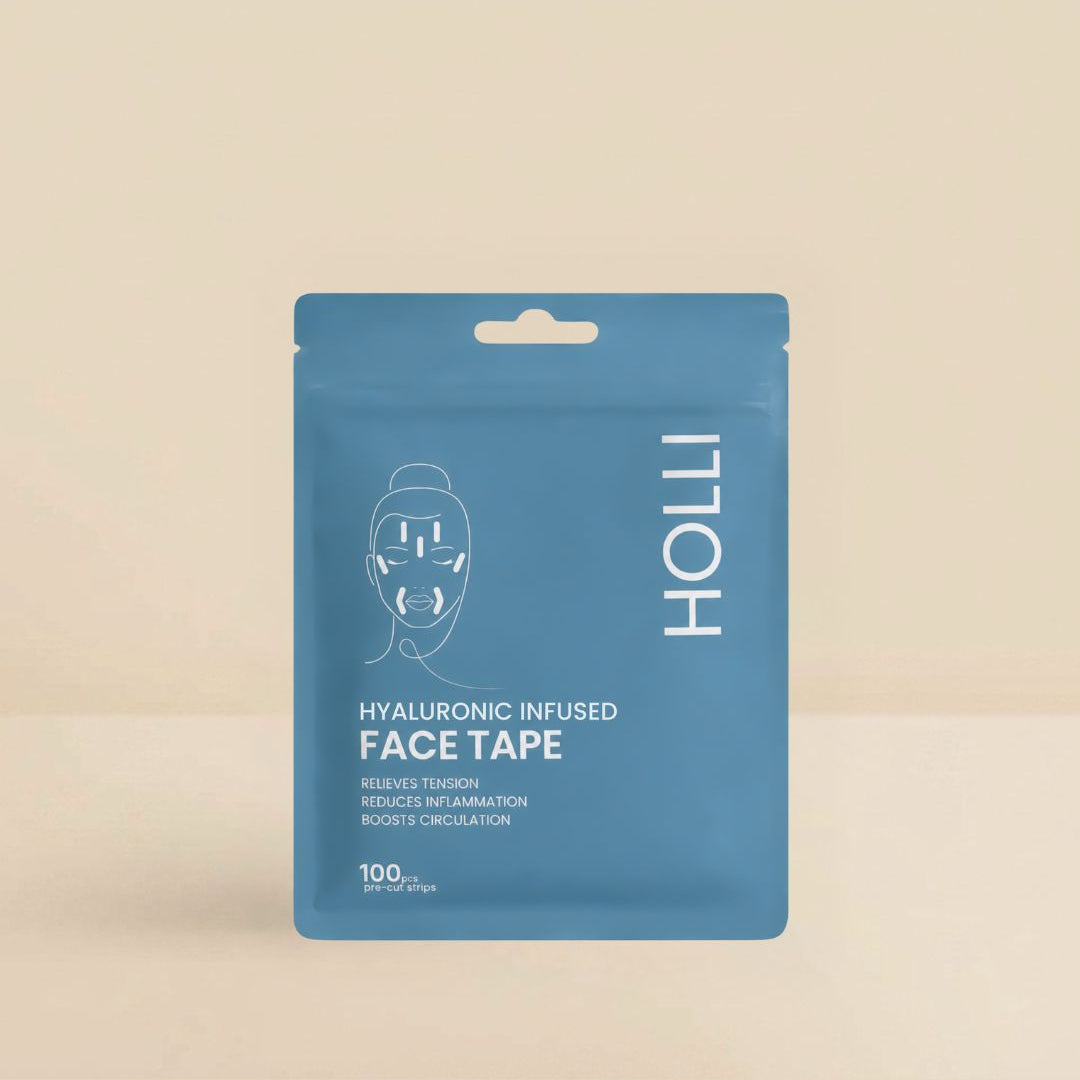A blue stand-up pouch of HOLLI Hyaluronic Infused Face Tape on a warm beige background. The packaging features a white line drawing of a face with tape applied, alongside the brand name 'HOLLI' in white vertical text.