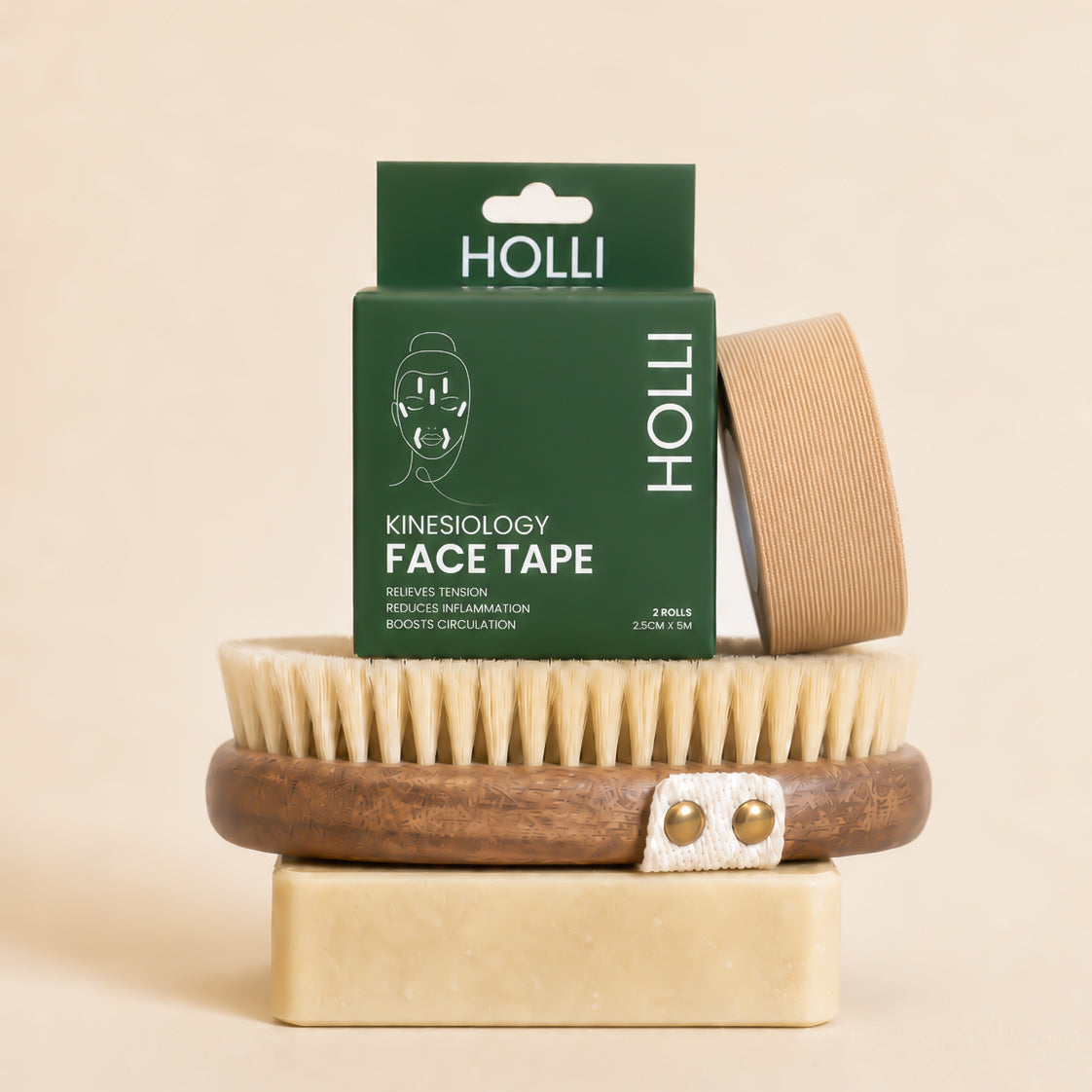 Holli kinesiology face tape with packaging and a wooden brush on a beige background