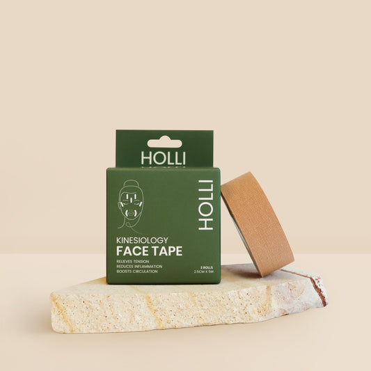 Green box of HOLLI kinesiology face tape on a beige background