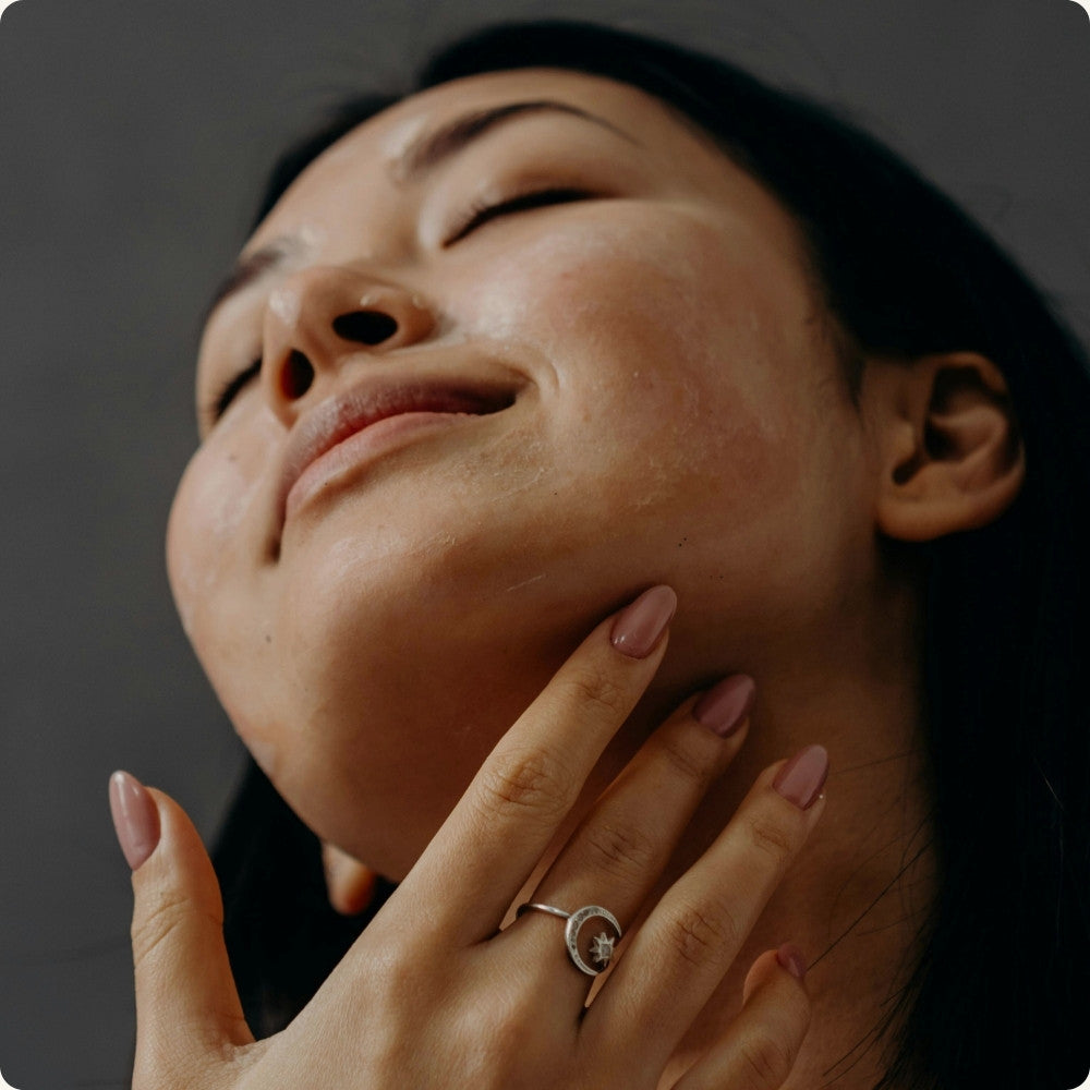 Woman massaging jawline to promote circulation & collagen